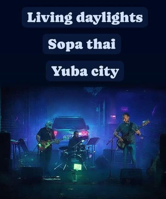 Live band performing on a blue-lit stage with three text banners: 'Living daylights', 'Sopa thai', 'Yuba city'.